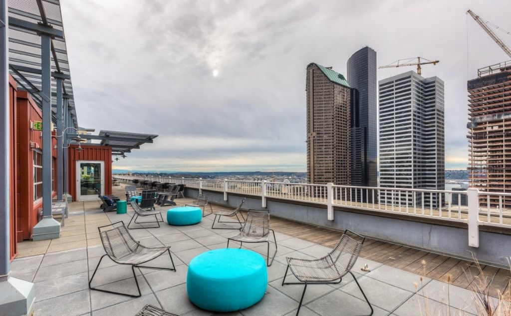 A rooftop patio with a view of the city skyline.