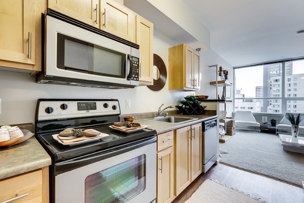 A modern kitchen with wooden cabinets and a black stove top oven.