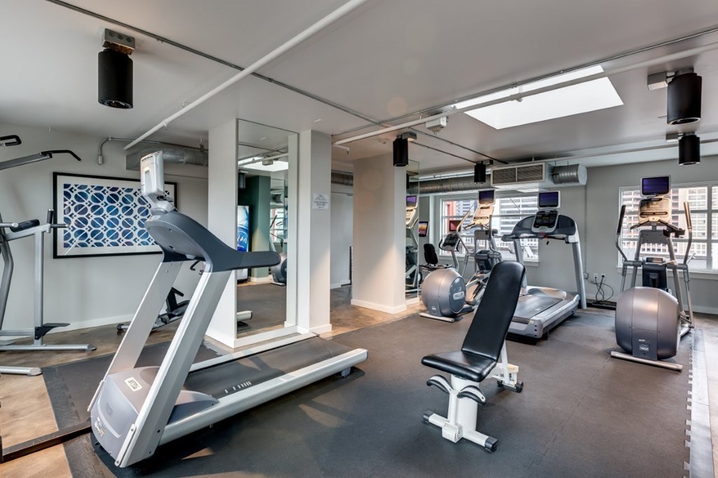 A gym with treadmills, exercise balls, and other equipment.