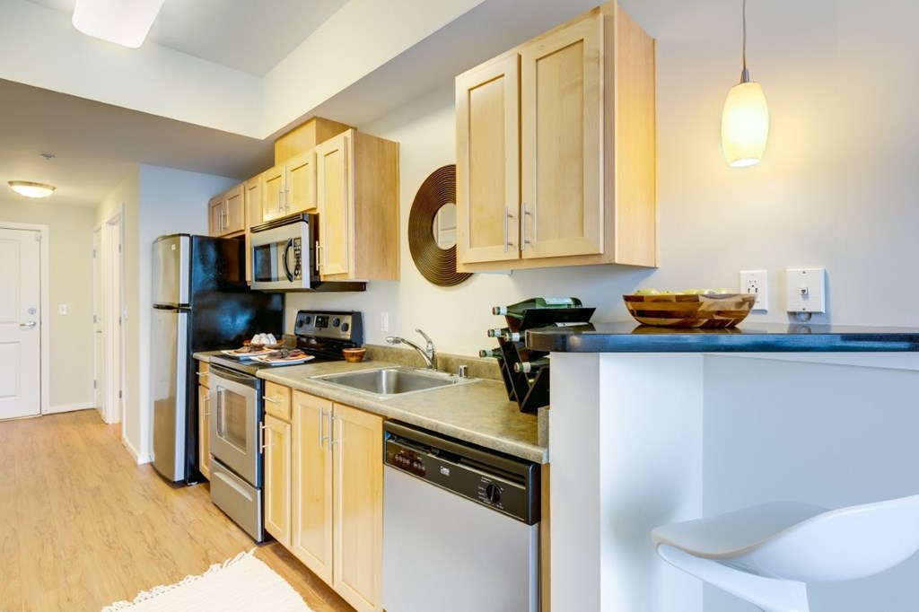 A kitchen with wooden cabinets and a white counter.
