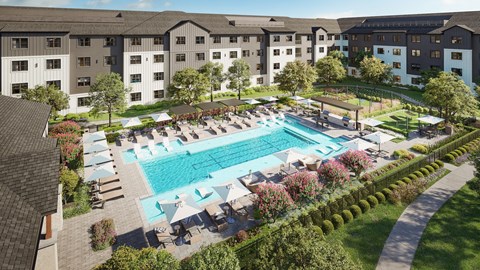A large swimming pool surrounded by lounge chairs and umbrellas in front of apartment buildings.