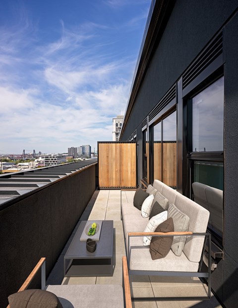 a living room with a couch and a coffee table on a balcony