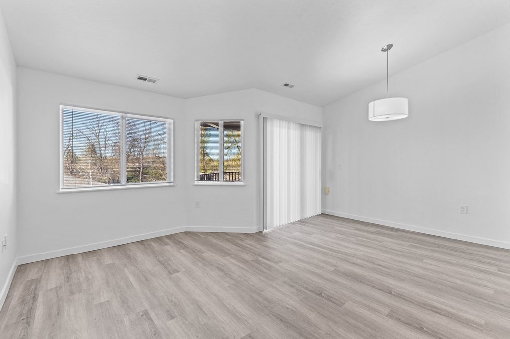 an empty living room with white walls and a window