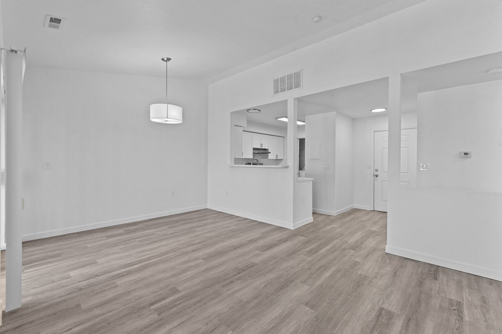 an empty living room with white walls and wood flooring