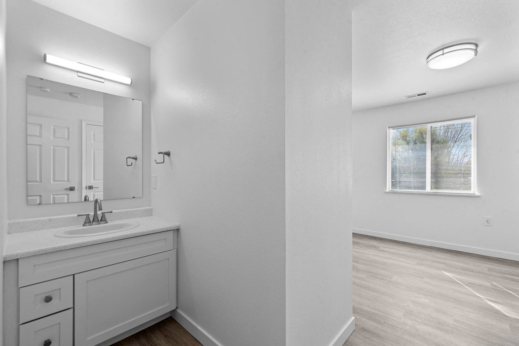 a white bathroom with a sink and a mirror
