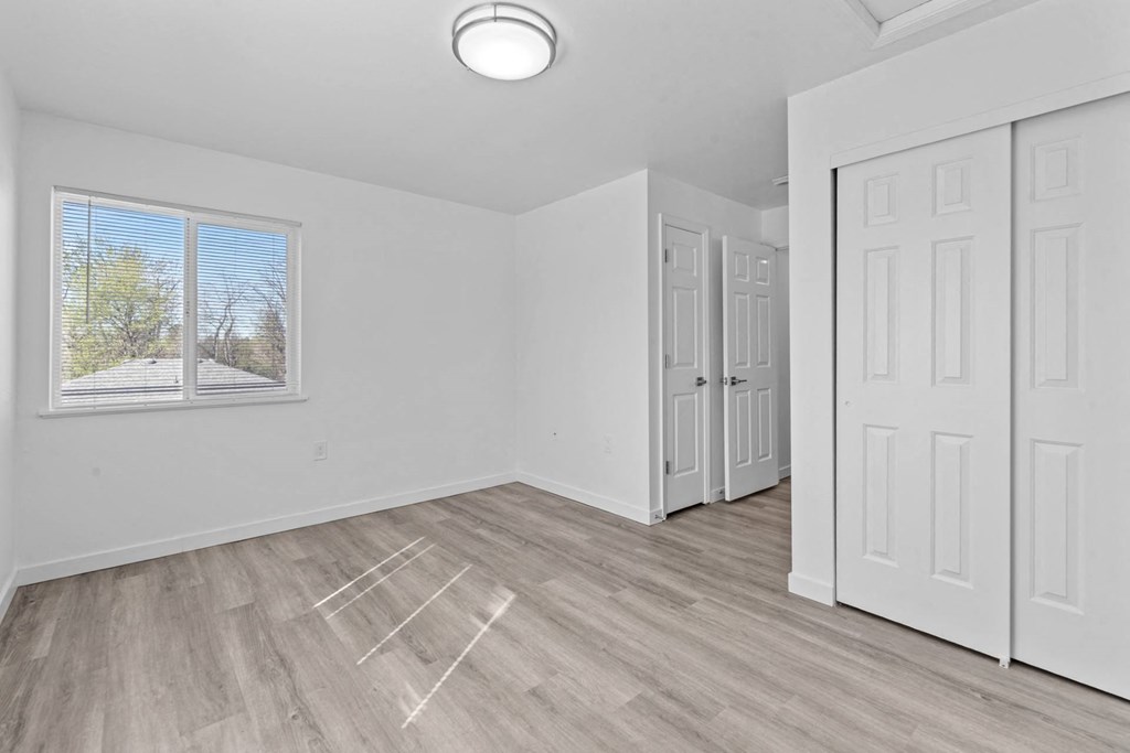 an empty living room with white walls and a window