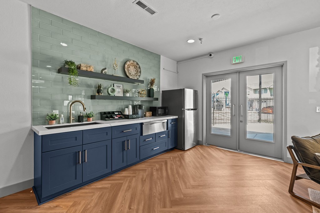 a kitchen with blue cabinets and a sliding glass door
