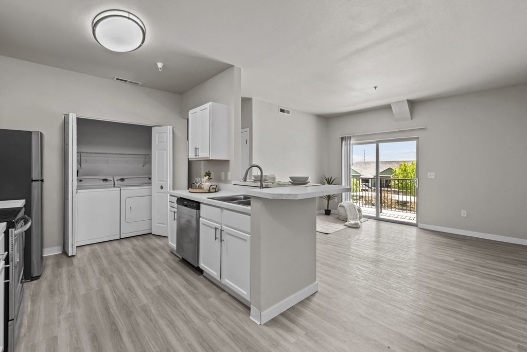 an open kitchen and living room with a door to a balcony