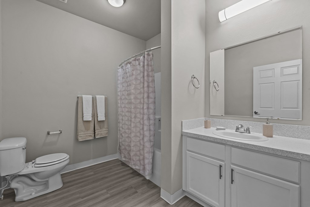 a bathroom with a toilet sink and shower and a mirror