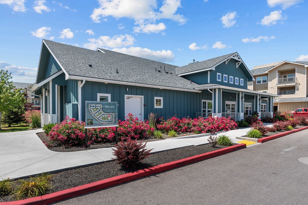 a blue building with pink flowers in front of it
