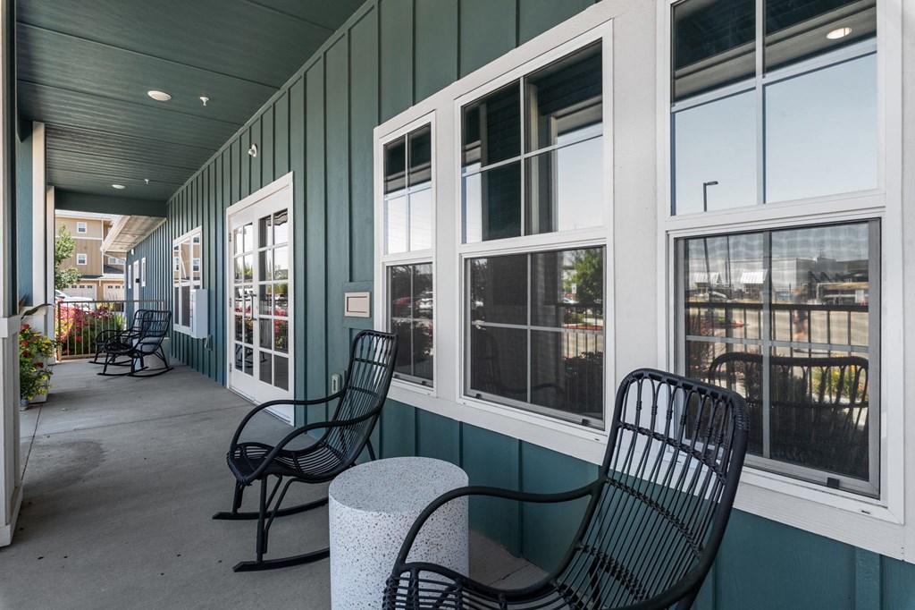 a porch with two chairs and a table