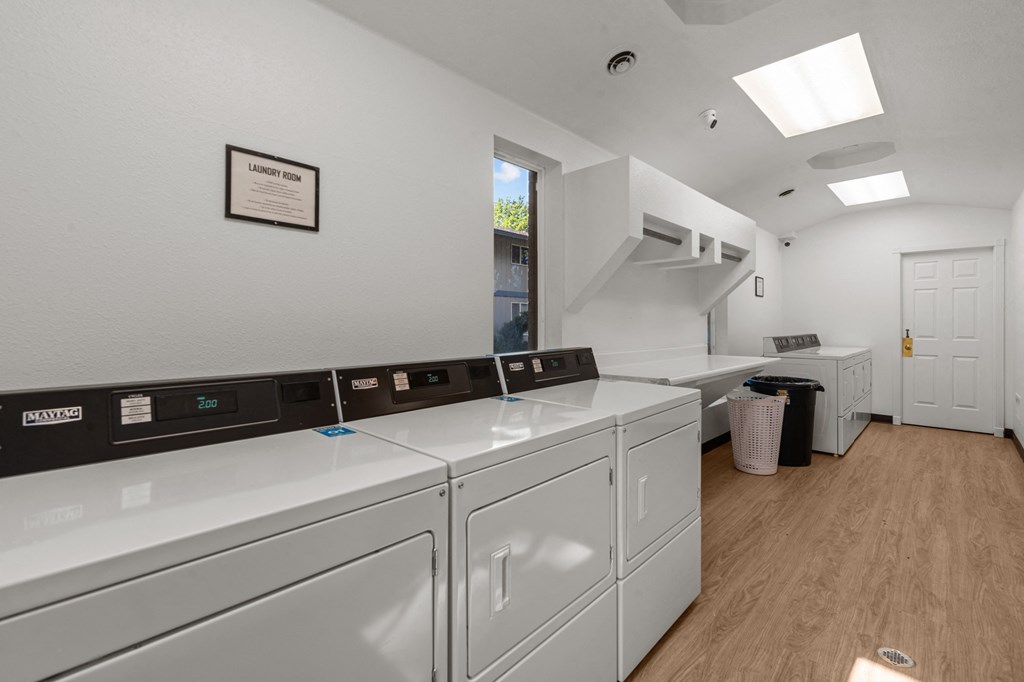 Curtis Apartments laundry room is equipped with washer and dryer and a window