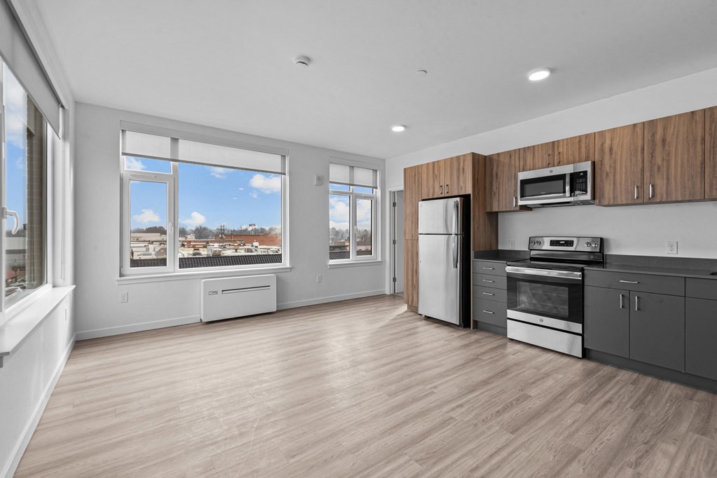 a kitchen with a stove and a refrigerator and a window