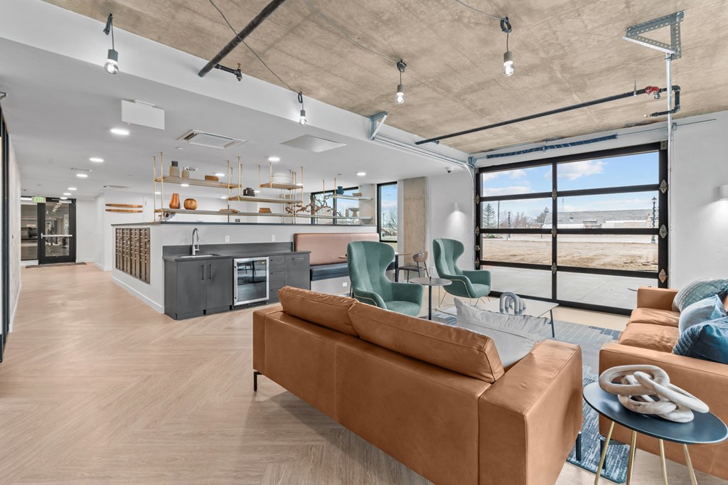 a living room with couches and a kitchen and a large window