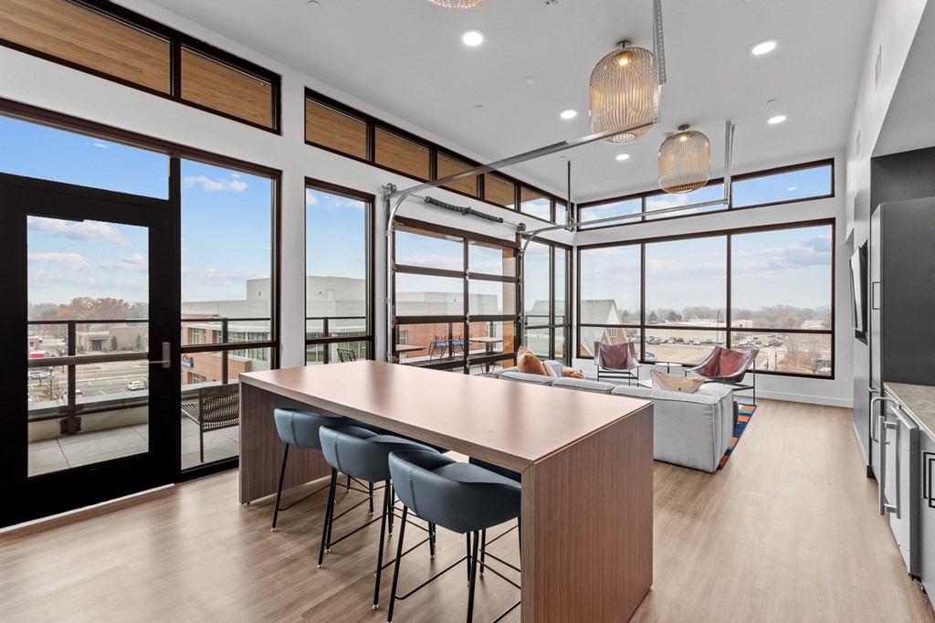 a kitchen and living room with large windows and a table and chairs