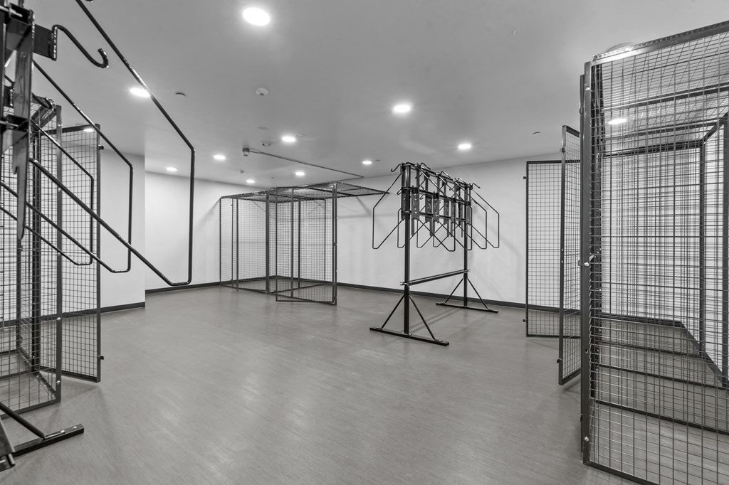 a large white room with many cages and a white wall in the background
