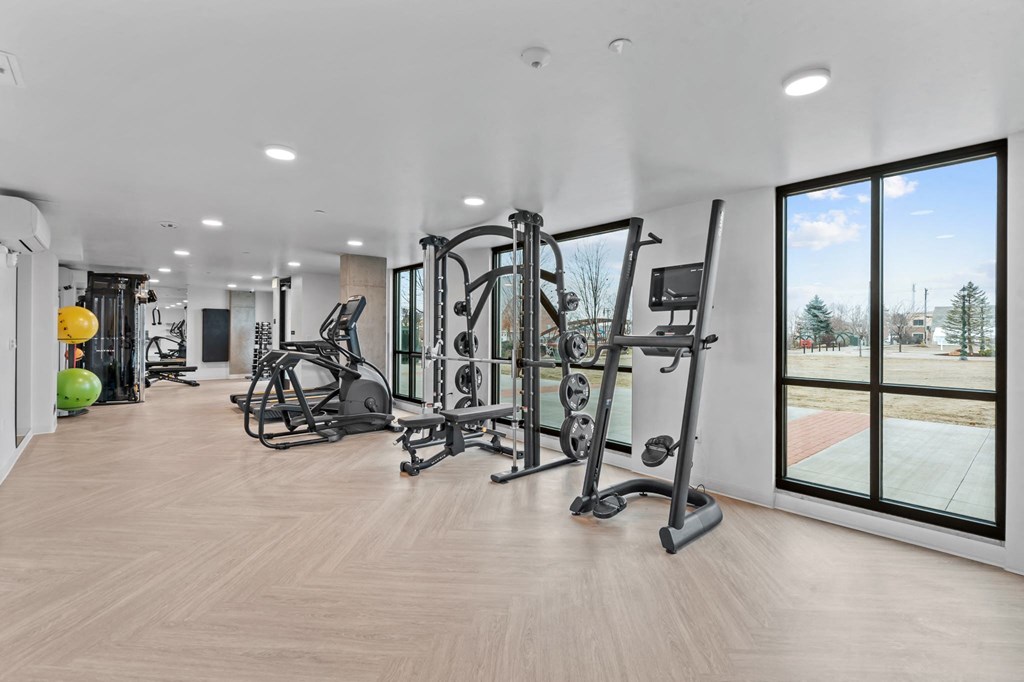 a gym with exercise equipment and large windows