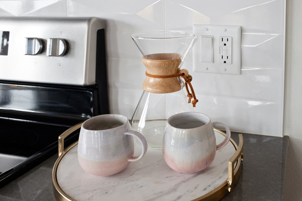 Grant Park Village shot of coffee maker and cups with electric stove in background
