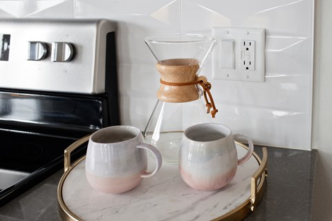 Grant Park Village shot of coffee maker and cups with electric stove in background