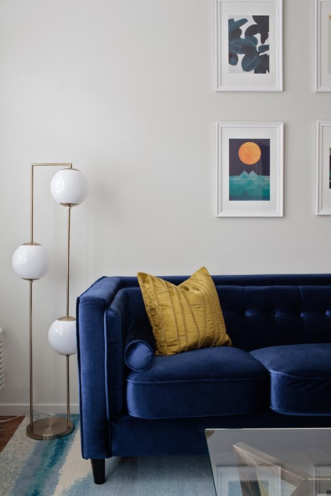 Grant park village shot of lights and art wall with blue velvet couch