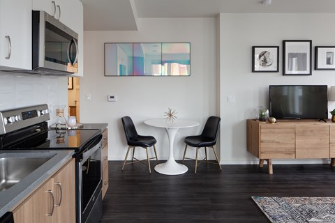 Grant Park Village media stand with television and  white table with blue chairs