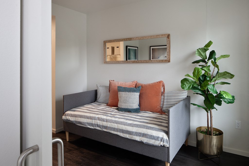 Grant Park Village bed with orange pillows and potted plant