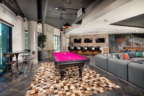 A pool table is in the middle of a room with a checkered floor.
