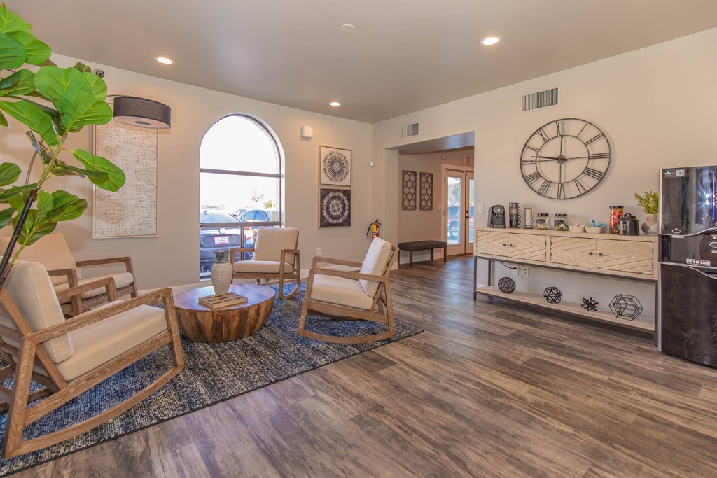 A living room with a wooden floor and a large clock on the wall.