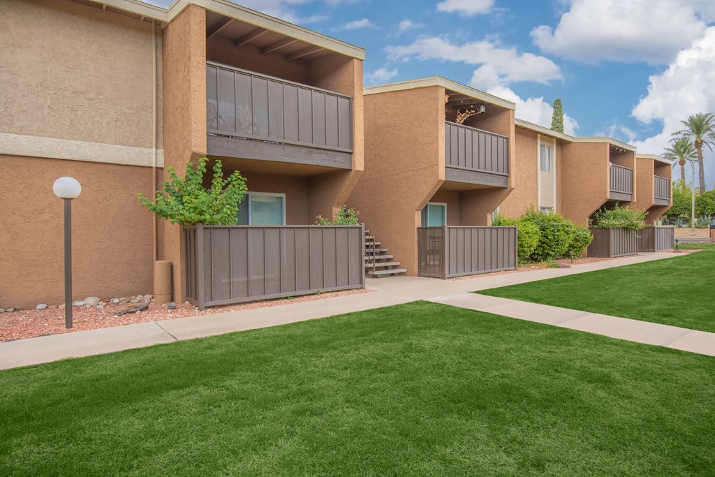 Apartment complex with green lawn in front.