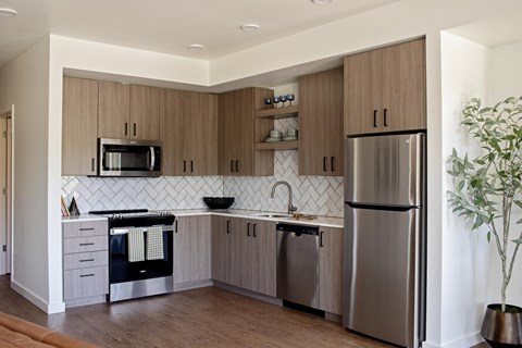 a modern kitchen with stainless steel appliances and wooden cabinets
