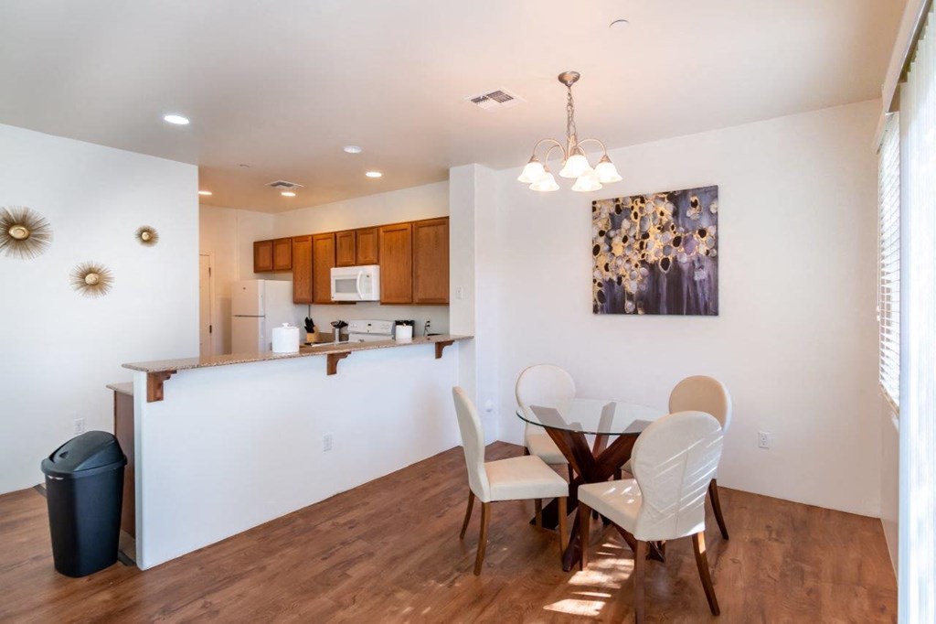 A kitchen with a dining table and chairs.