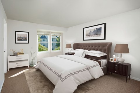 A bedroom with a large bed and a window overlooking a blue house.
