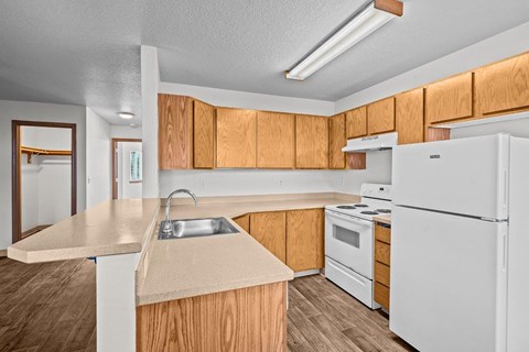a kitchen with white appliances and wooden cabinets