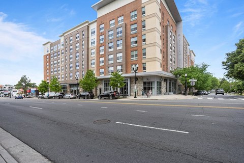 A large red brick building with a parking lot in front.
