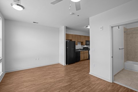 A kitchen with a black refrigerator and wooden cabinets.