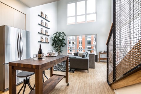 a living room with a table and a refrigerator