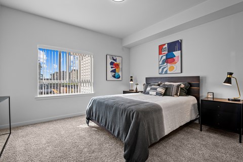 a bedroom with a bed and a large window