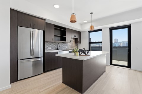 A modern kitchen with a large island and stainless steel appliances.