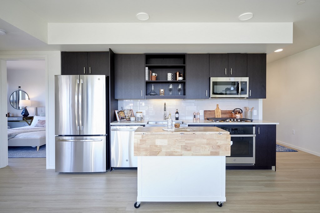 a kitchen with stainless steel appliances and a marble island in the middle