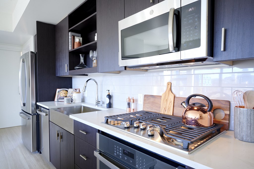 a kitchen with a stove and a microwave and a sink
