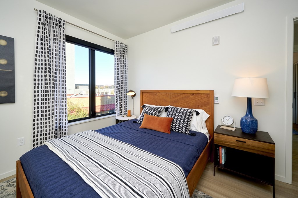 a bedroom with a bed and a large window