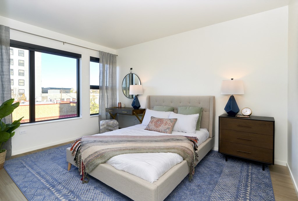 a bedroom with a bed and a large window