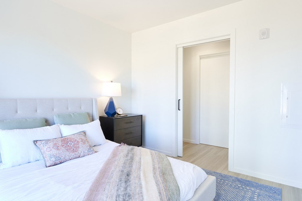 a bedroom with a bed and a door to a bathroom