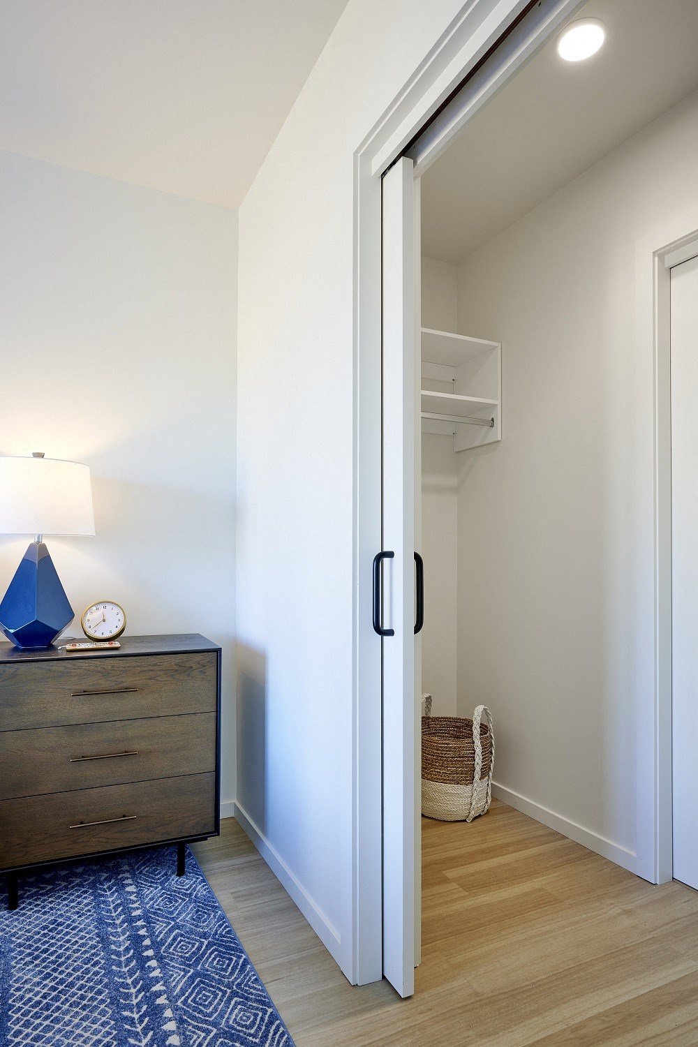 a door leading to a bedroom with a dresser and a closet