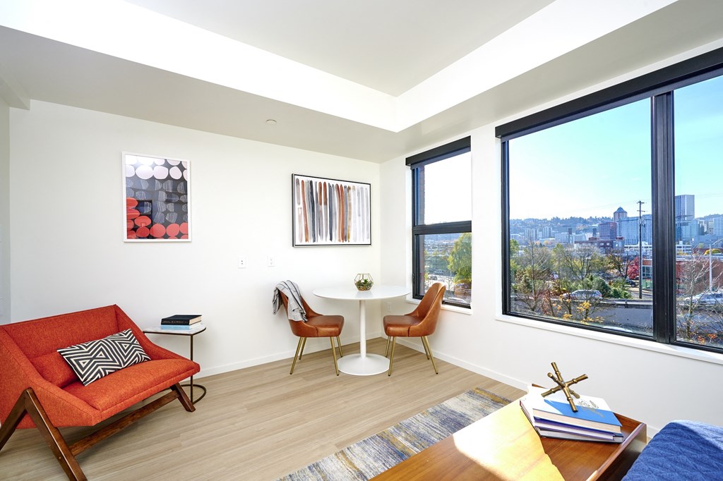 a living room with a large window and a couch and a table with two chairs