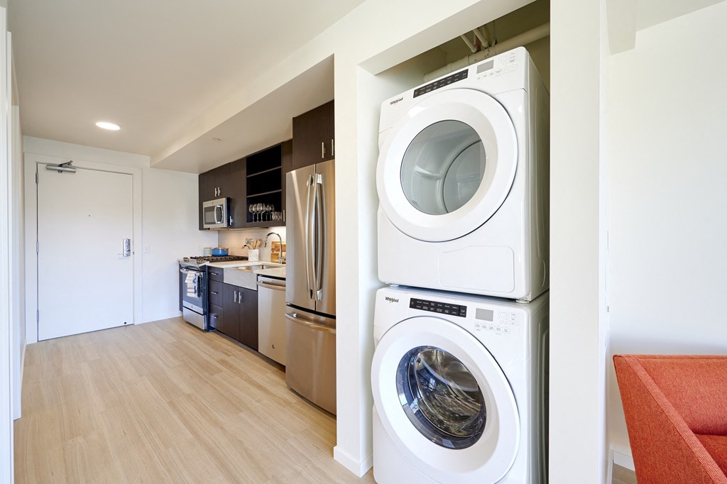a washer and dryer in a living room next to a kitchen