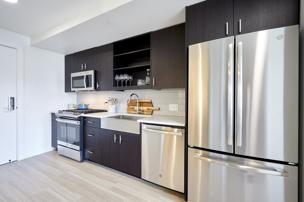 a kitchen with stainless steel appliances and black and white cabinets