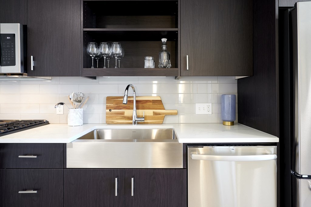 a kitchen with a sink and cabinets and a refrigerator