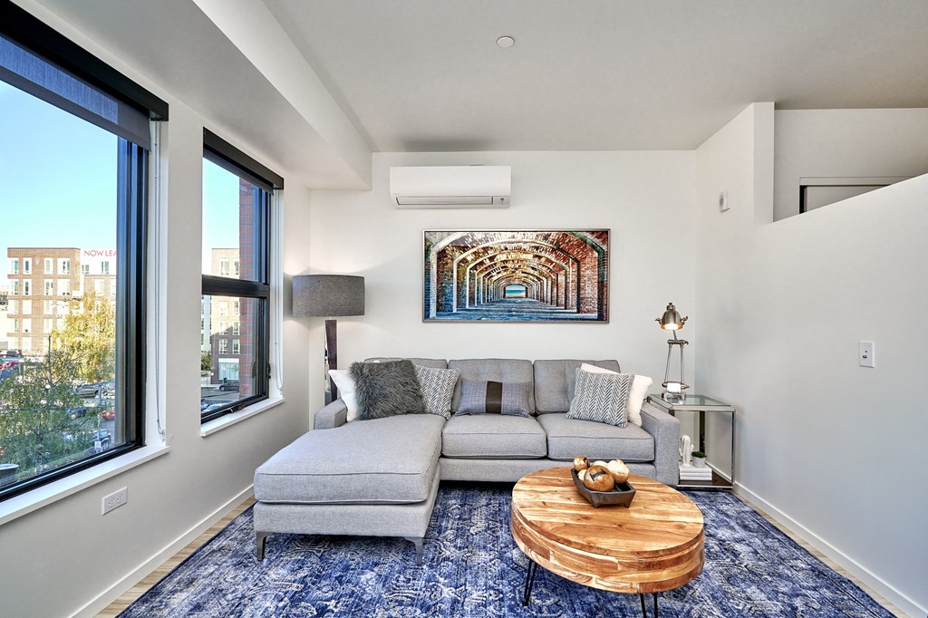 a living room with a couch and a coffee table and a large window