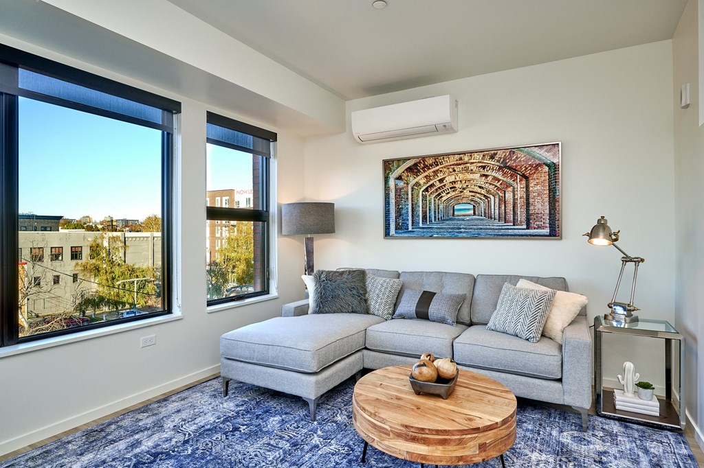 a living room with a couch and a coffee table and large windows